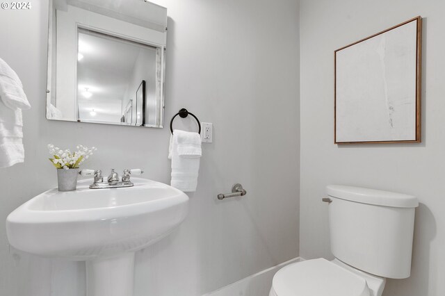 half bathroom featuring a sink and toilet