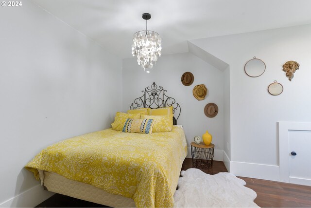 bedroom featuring baseboards, a chandelier, and dark wood-type flooring