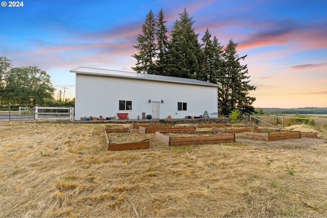 exterior space with a garden, a pole building, a lawn, and an outbuilding