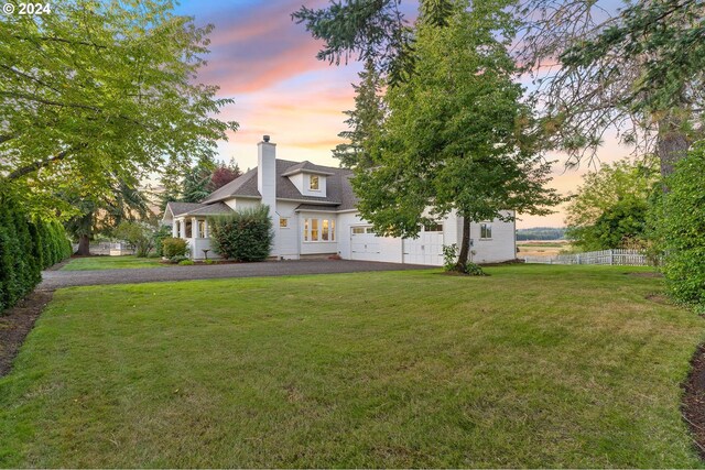 exterior space with driveway, a chimney, fence, and a yard