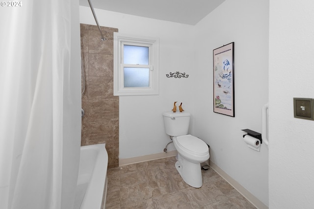 bathroom with toilet and tiled shower / bath