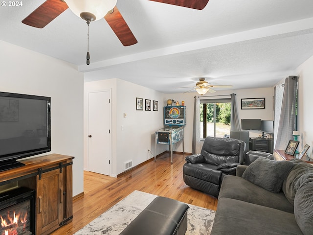 living room with a textured ceiling and light hardwood / wood-style flooring