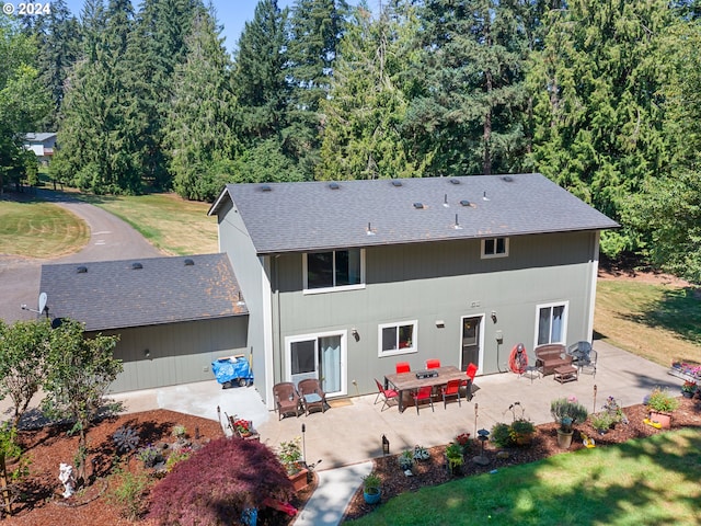 back of property with a yard and a patio