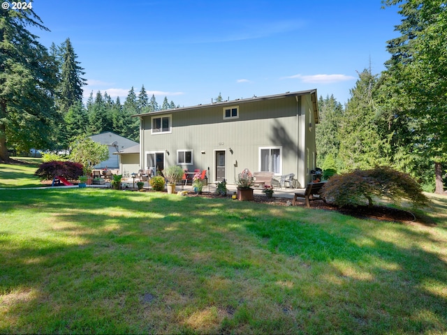 rear view of property with a lawn and a patio