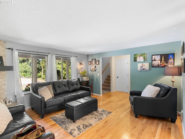 living room featuring light hardwood / wood-style floors and a textured ceiling