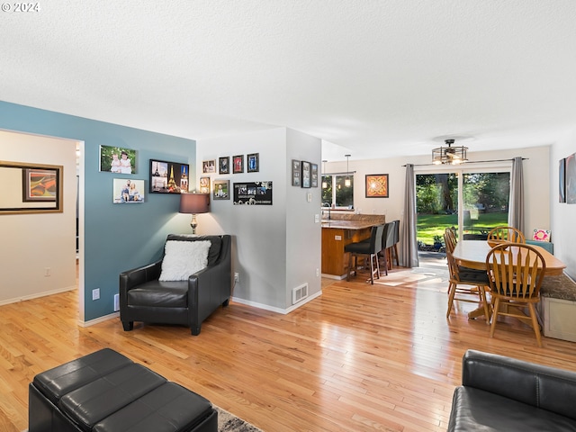 living room featuring a textured ceiling and light hardwood / wood-style flooring