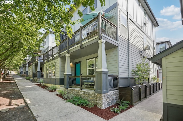 view of side of home featuring a porch and a balcony