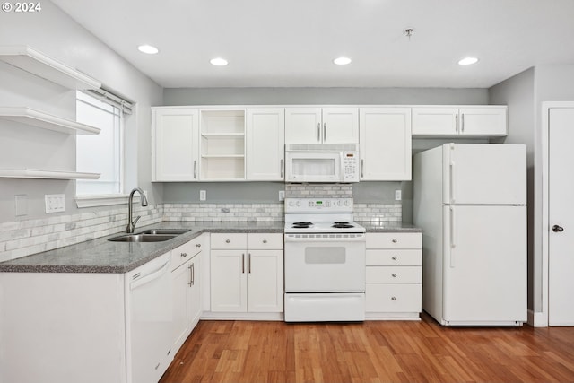 kitchen featuring white appliances, backsplash, white cabinets, sink, and light hardwood / wood-style floors