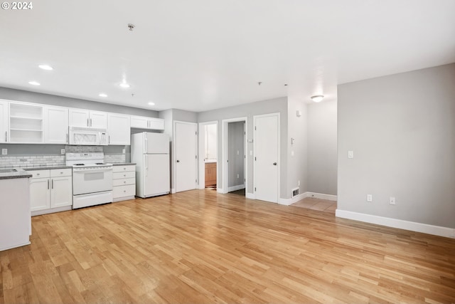 kitchen with white appliances, sink, decorative backsplash, light wood-type flooring, and white cabinetry