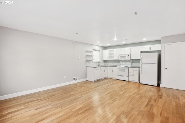 kitchen with white cabinetry, sink, light hardwood / wood-style floors, and white appliances