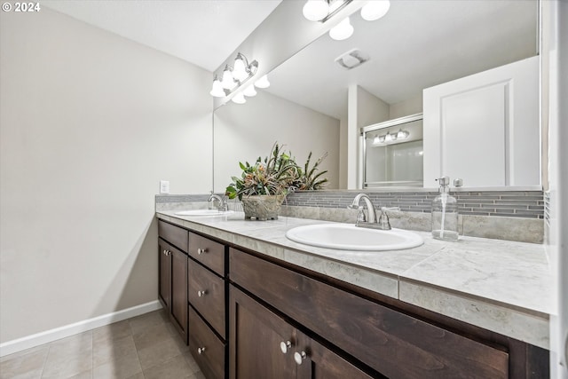 bathroom featuring tile patterned flooring, decorative backsplash, and vanity