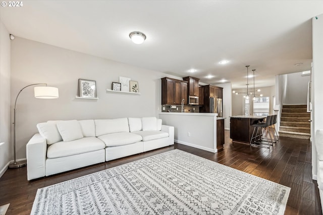 living room featuring sink and dark wood-type flooring