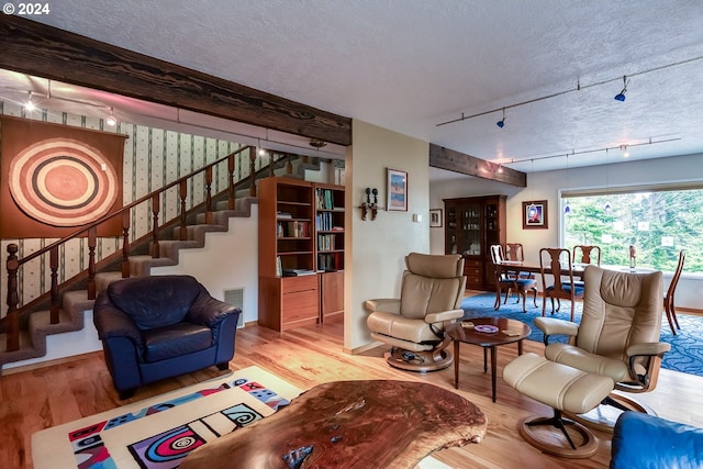 living room featuring a textured ceiling, rail lighting, and hardwood / wood-style floors