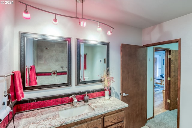 bathroom featuring a shower, hardwood / wood-style floors, and vanity