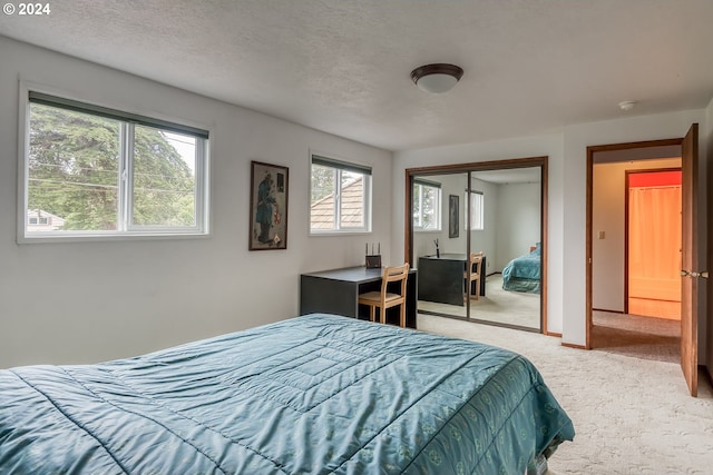 carpeted bedroom featuring a textured ceiling and a closet