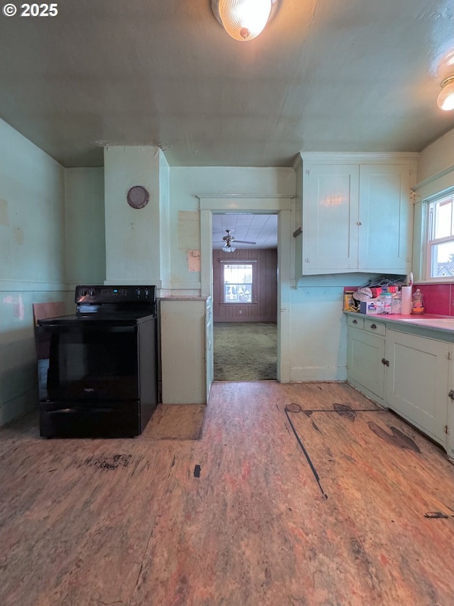 kitchen featuring electric range, a wealth of natural light, and white cabinets