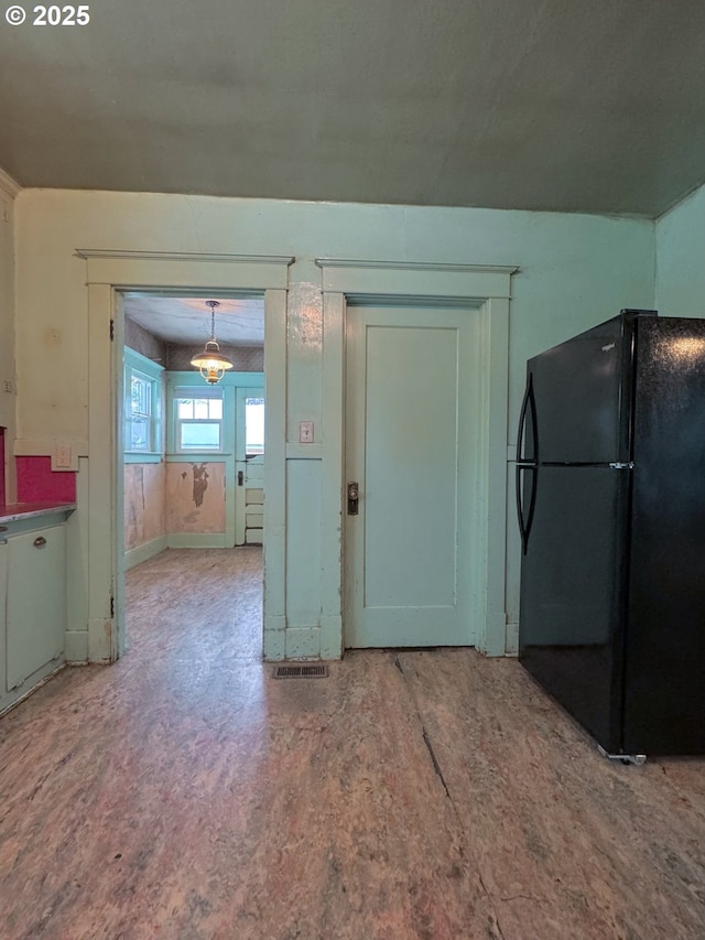 kitchen with decorative light fixtures and black fridge