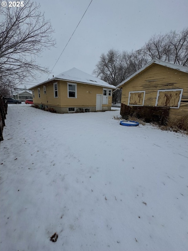 view of snow covered back of property