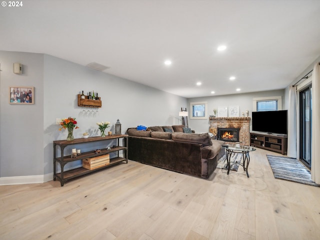 living room with light wood-type flooring and a fireplace