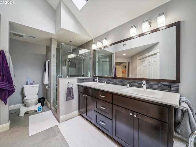 bathroom with tasteful backsplash, an enclosed shower, toilet, vanity, and lofted ceiling with skylight