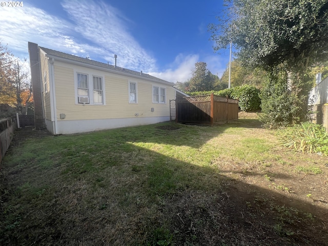 view of side of home with a yard