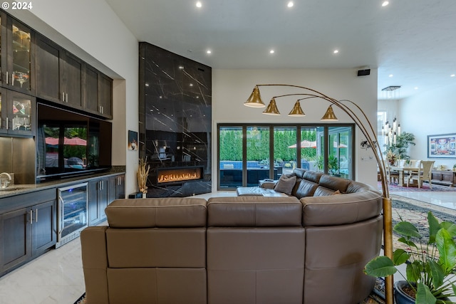 living room featuring wine cooler, a fireplace, and sink