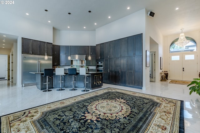 kitchen featuring a kitchen breakfast bar, a kitchen island with sink, and a high ceiling