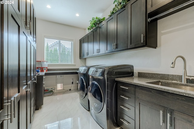 washroom featuring washer and dryer, cabinets, and sink