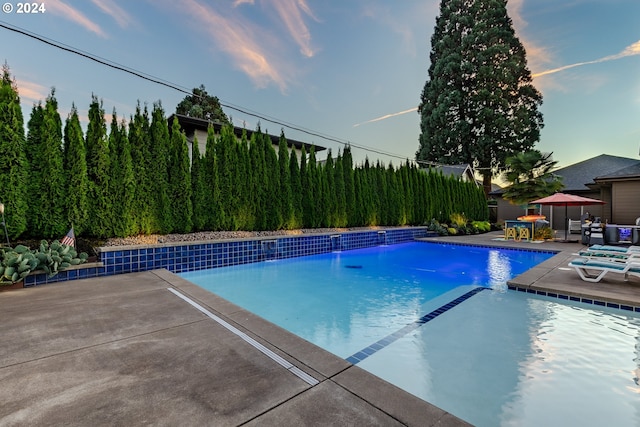 view of swimming pool featuring pool water feature and a patio