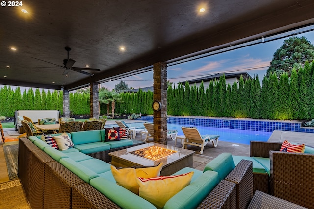 patio terrace at dusk with ceiling fan and an outdoor living space with a fire pit