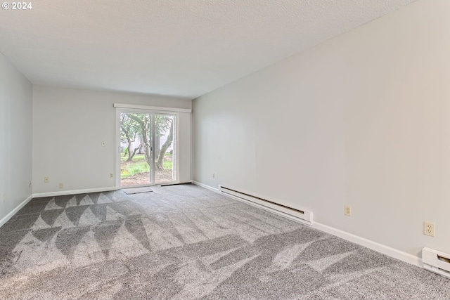 carpeted spare room featuring a textured ceiling and baseboard heating