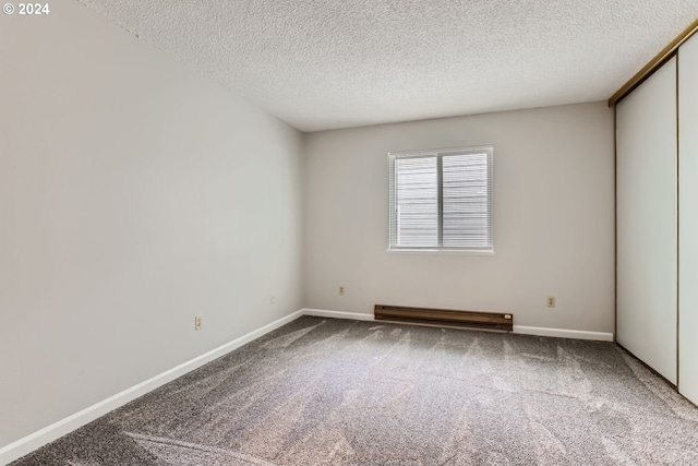 carpeted spare room featuring a textured ceiling