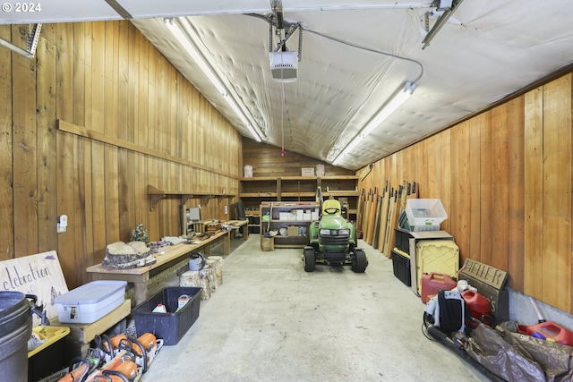 garage with a garage door opener and wood walls