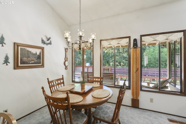 carpeted dining room featuring a notable chandelier and lofted ceiling