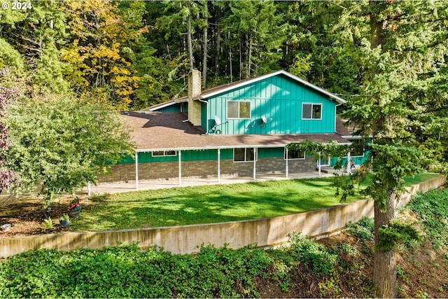 39145 Eagles Rest Rd, Dexter, OR 97431 - exterior space with a view of trees, a patio, a front lawn, a chimney, and board and batten siding
