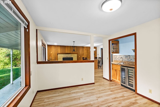 39145 Eagles Rest Rd, Dexter, OR 97431 - kitchen with beverage cooler, a sink, a fireplace, baseboards, and light wood-style floors