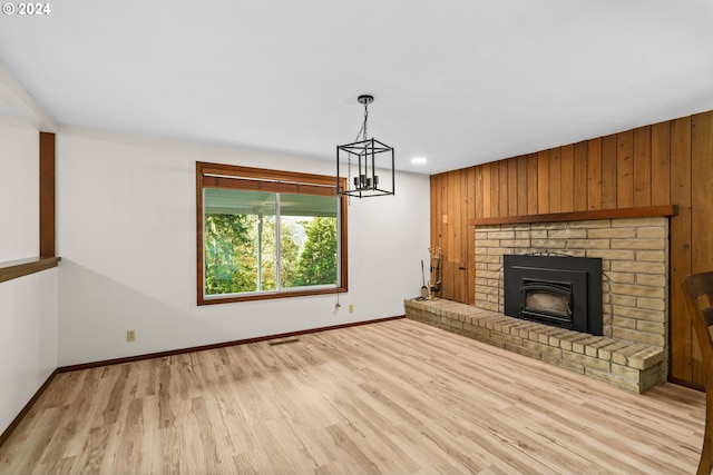 39145 Eagles Rest Rd, Dexter, OR 97431 - unfurnished living room with baseboards, wooden walls, a chandelier, and wood finished floors