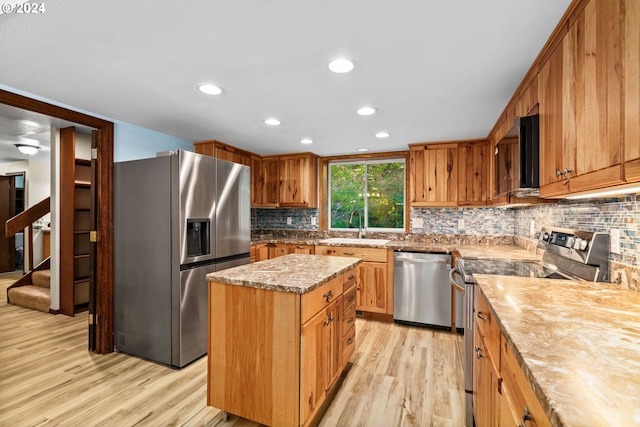 39145 Eagles Rest Rd, Dexter, OR 97431 - kitchen with a sink, a kitchen island, light wood-style floors, stainless steel appliances, and tasteful backsplash