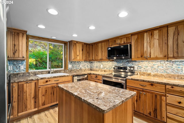 39145 Eagles Rest Rd, Dexter, OR 97431 - kitchen with a sink, brown cabinetry, stainless steel appliances, and light wood-style flooring