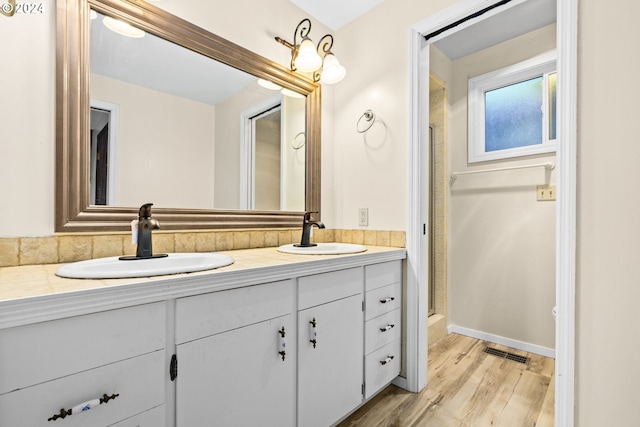 39145 Eagles Rest Rd, Dexter, OR 97431 - bathroom with double vanity, visible vents, wood finished floors, and a sink