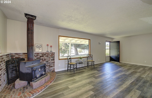 living room with a wood stove, hardwood / wood-style floors, and a textured ceiling