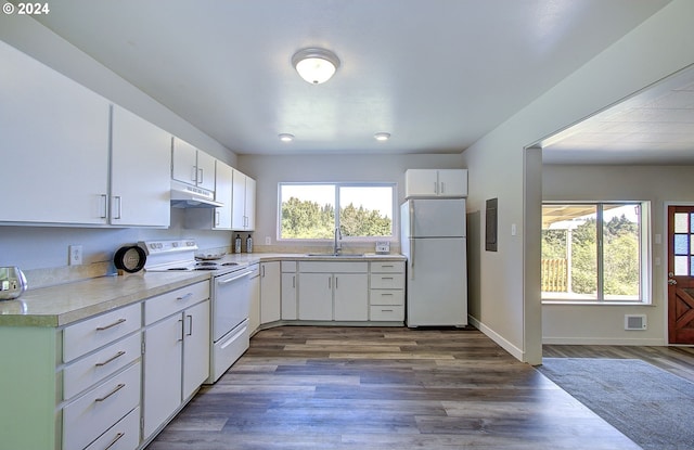 kitchen with white cabinets, white appliances, plenty of natural light, and sink