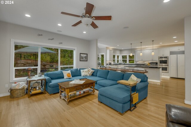 living room with light hardwood / wood-style flooring and ceiling fan