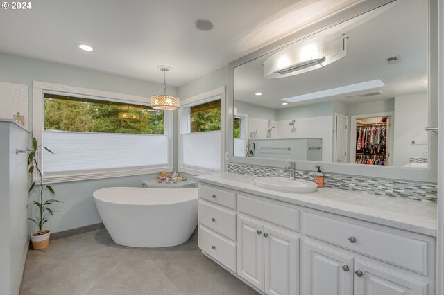 bathroom with a wealth of natural light, backsplash, a skylight, and vanity