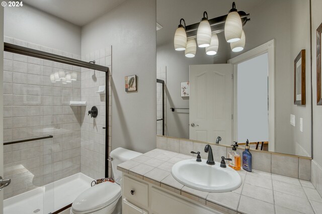 bathroom featuring vanity, a shower with shower door, and toilet