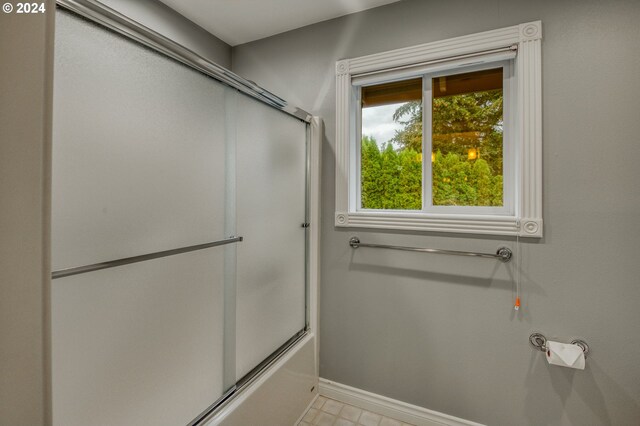 bathroom with bath / shower combo with glass door