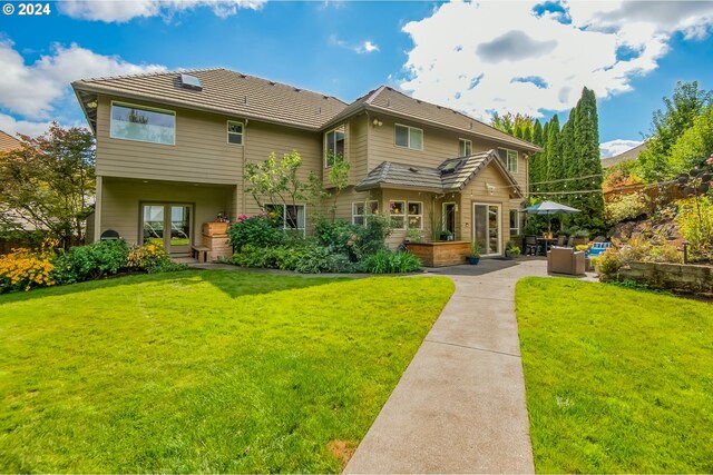 back of property featuring a yard and a patio