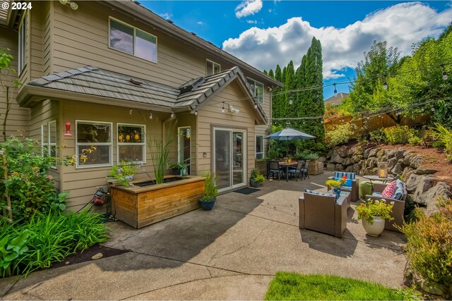 back of house with an outdoor living space and a patio area