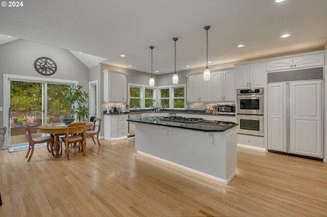 kitchen with white cabinets, a wealth of natural light, hanging light fixtures, and stainless steel appliances