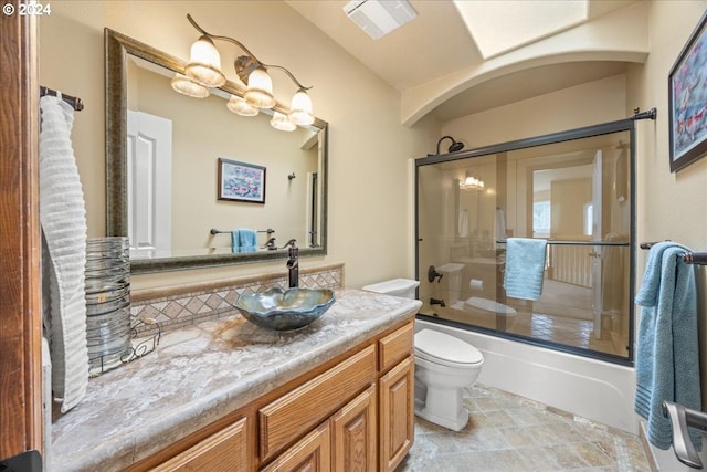 full bathroom featuring vanity, tile patterned flooring, shower / bath combination with glass door, and toilet